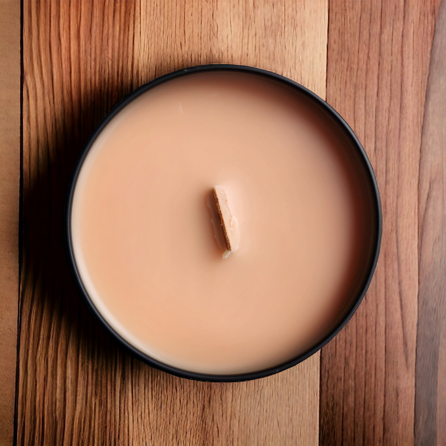 orange candle with a wooden wick on a wood counter